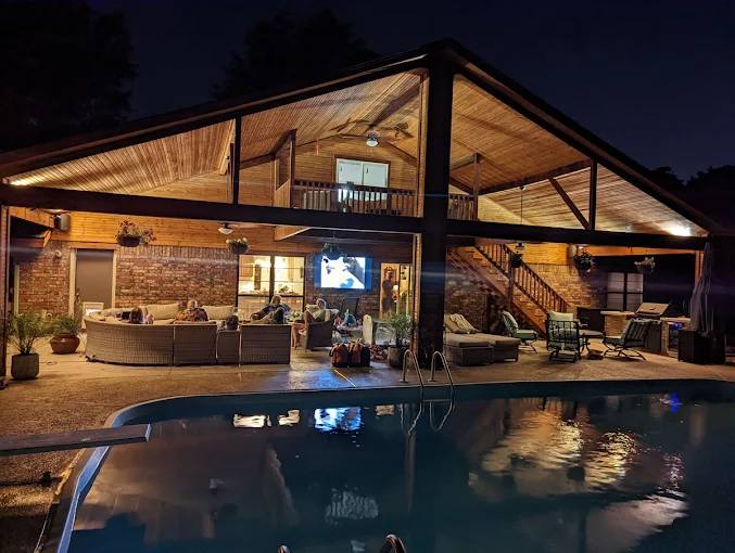 D&S Properties custom patio cover with pool and outdoor living area at night